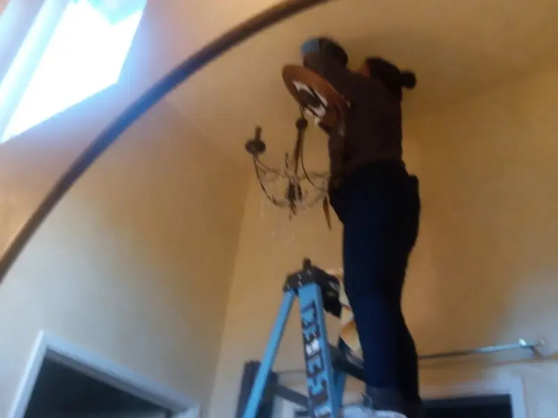 Electrician installing a chandelier in a Rosita residence